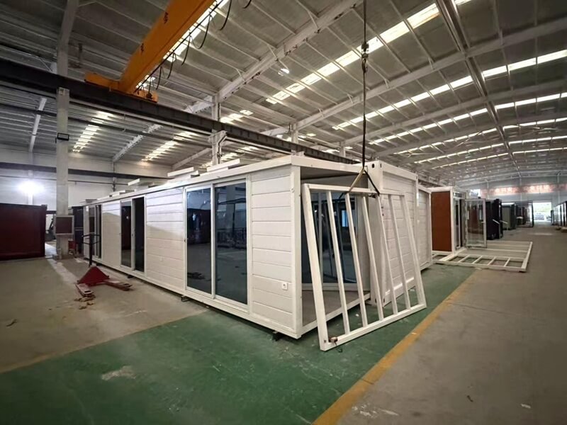 Workers assembling modular container house in factory